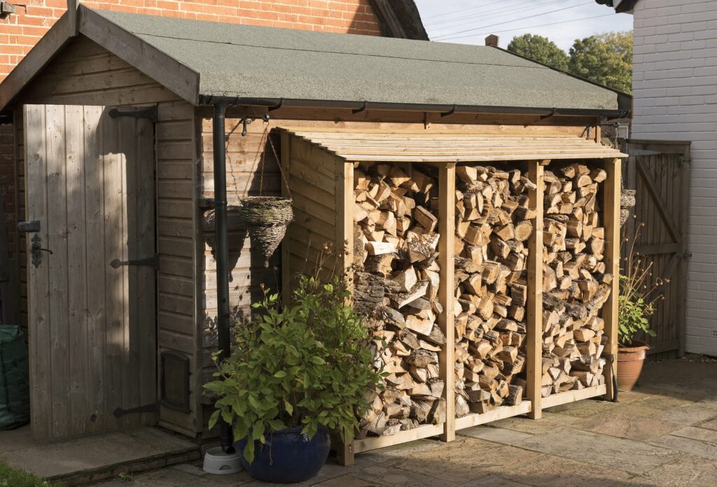 petit cabanon dans une cour avec stockage de bois